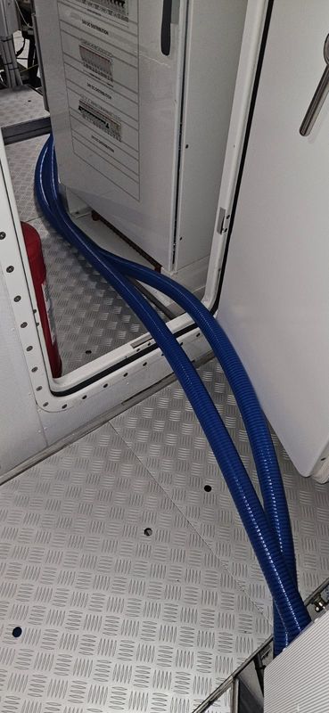 Blue hoses routed past the DC panel, Feb 2024 (purpose to be confirmed).