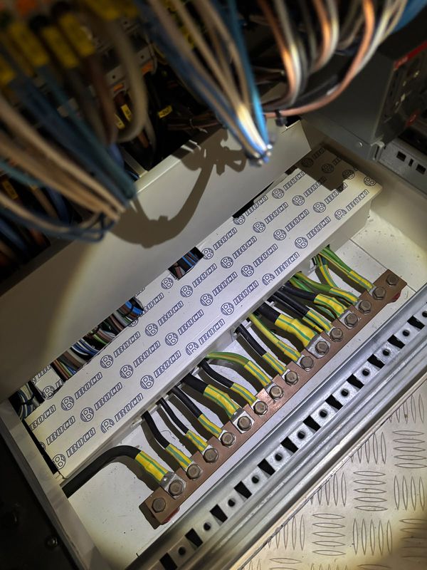 Main earth busbar from above, green/yellow bonds beneath the cable trunking.