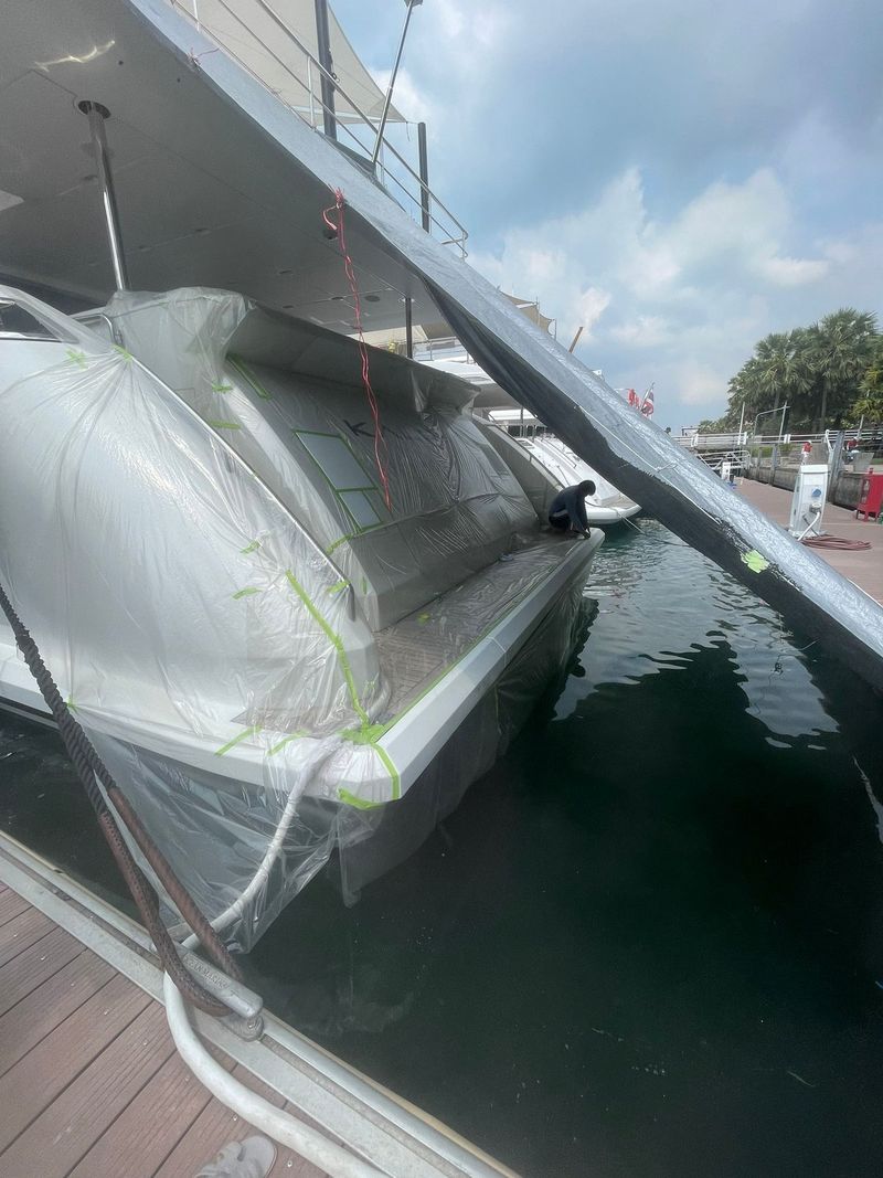 Plastic enclosure at the stern for exterior paint and gelcoat correction work, afloat