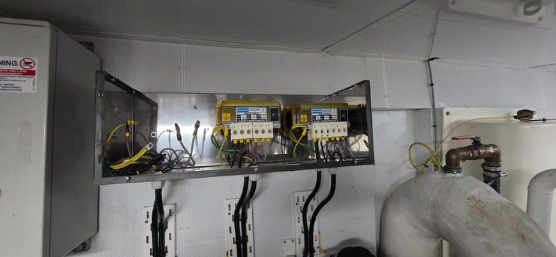 Open-frame line reactors mounted beside seawater piping in the machinery space